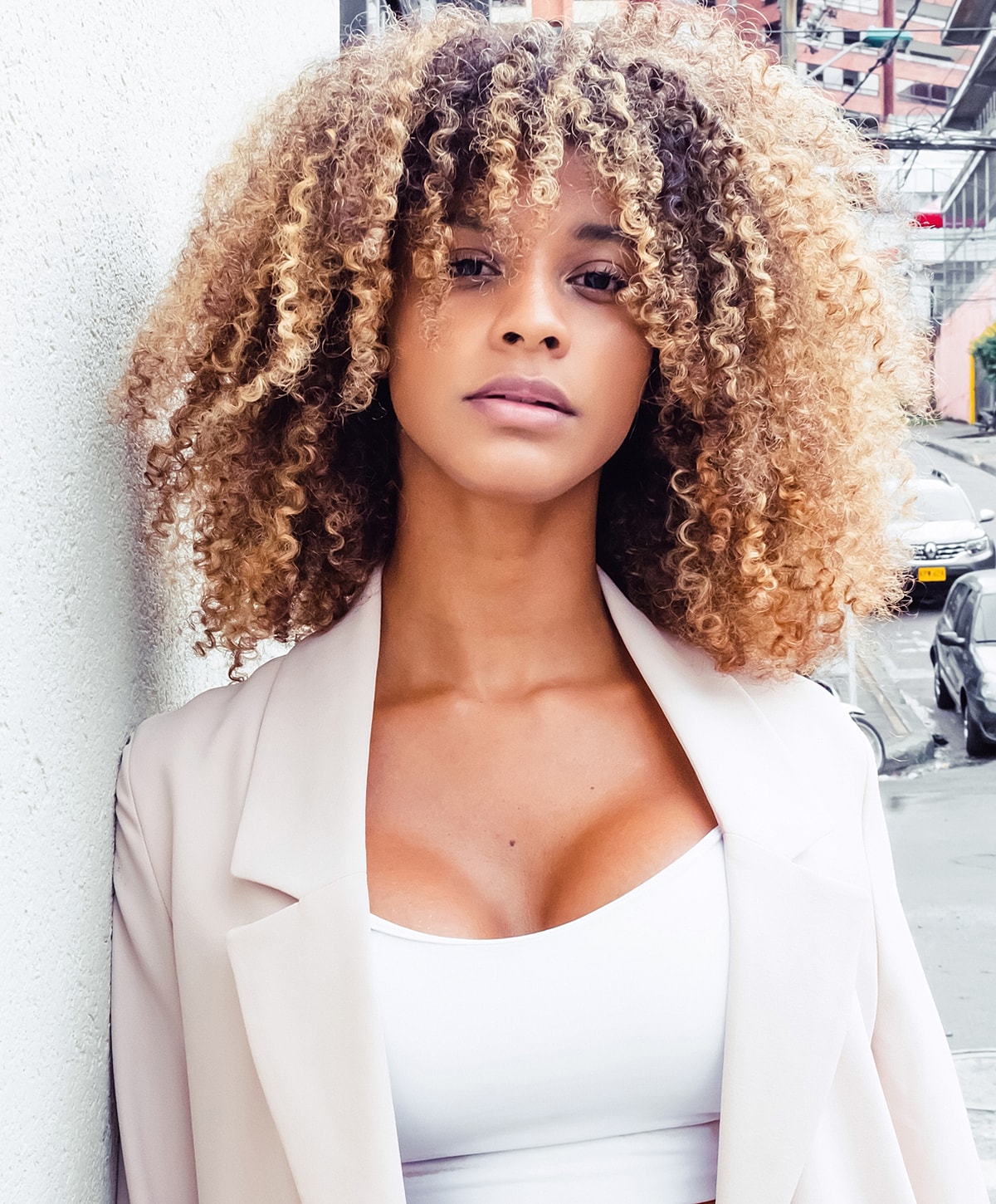 Woman with curly hair in stylish outfit.