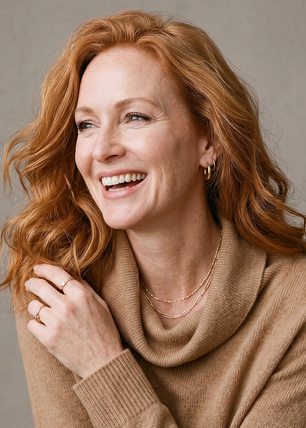 Smiling woman with red hair wearing jewelry.