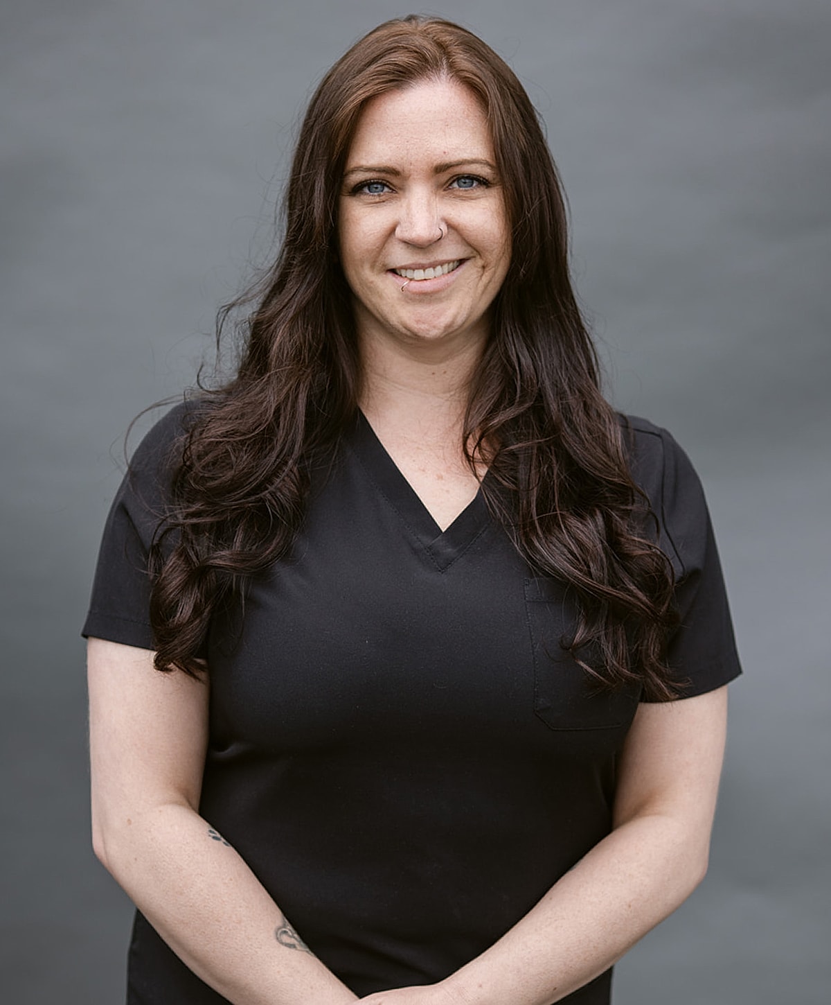 Female professional in a black outfit, smiling.