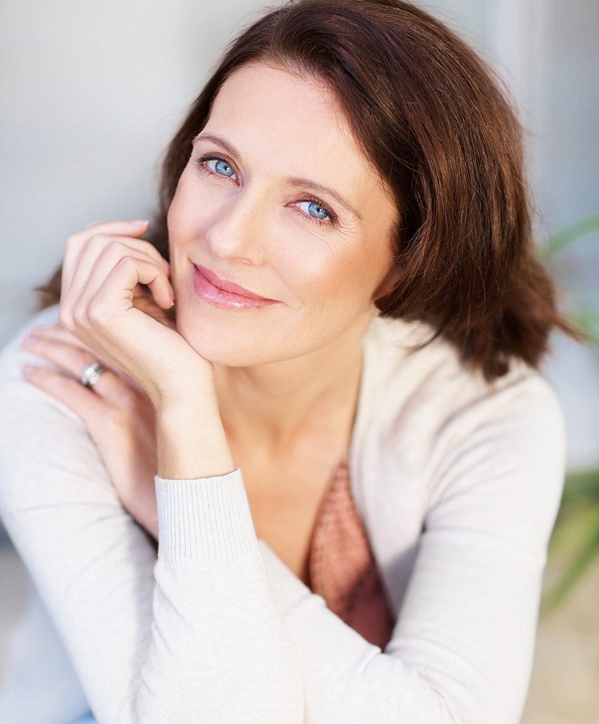 Smiling woman with blue eyes and casual attire.
