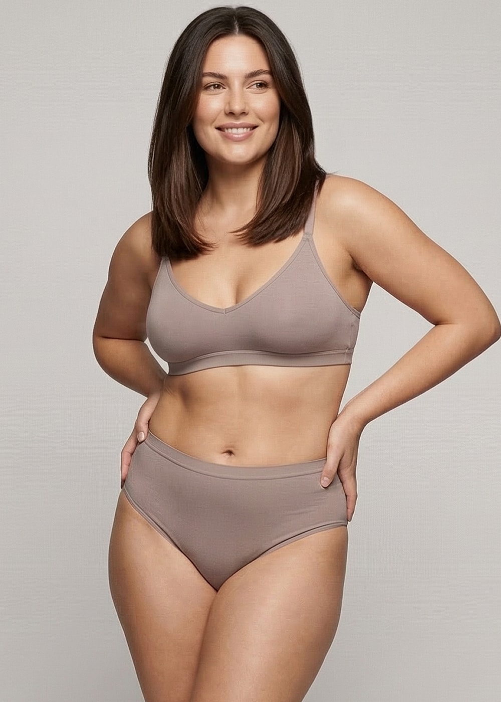 Model in comfortable brown lingerie smiling confidently.