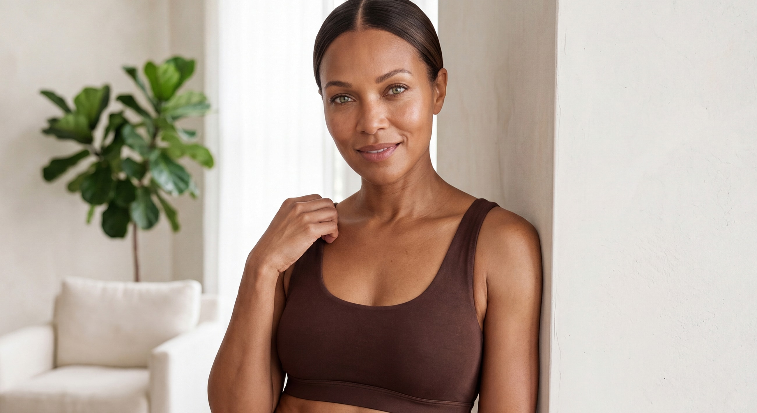 Woman smiling in a brown sports bra.